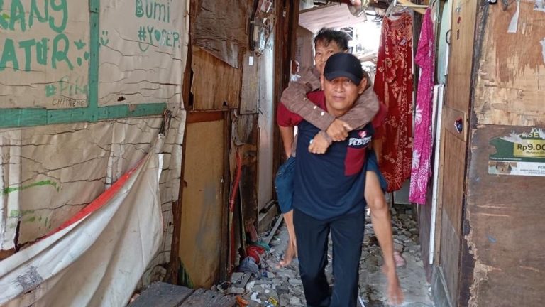 Seorang Pria Gendong Pasien di Jakarta Utara